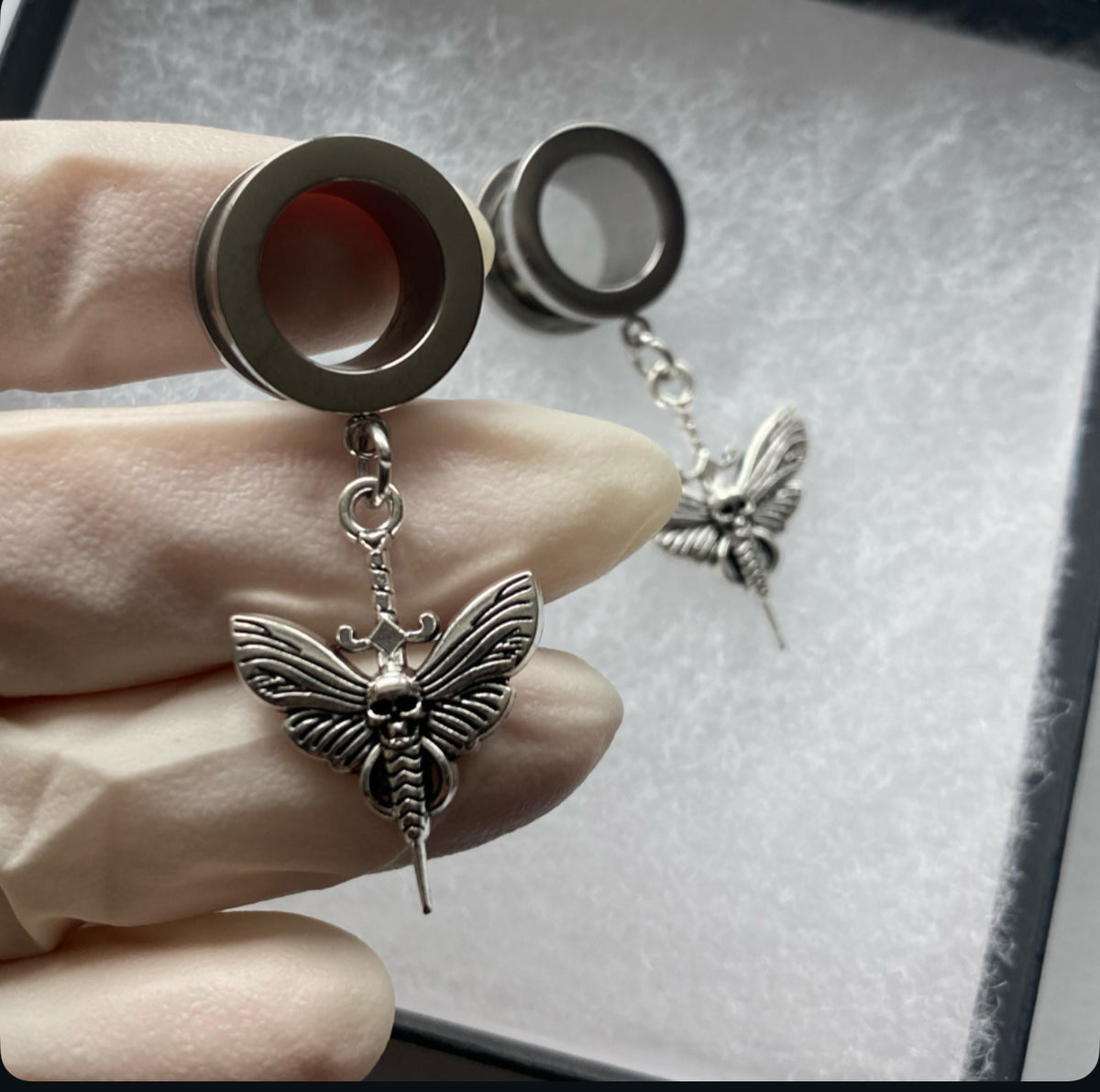 Death-moth dangle plug tunnels