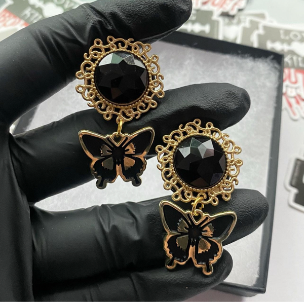 Golden butterfly dangle plugs for stretched lobes. 